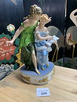 Full view of cast metal sculpture showing both figures and base