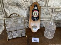Overall lot showing brass caddy with two decanters, separate decanter, and wall opener