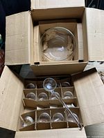 Opened box showing punch bowl in top layer and cups with ladle in lower layer