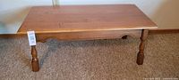 Full top and leg view of the rectangular maple coffee table.