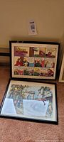 Two framed prints side by side on floor; one For Better or For Worse cartoon, one cityscape print