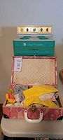 Full view of vintage turquoise Easy Bake oven on table with open Barbie doll clothes case full of doll clothes in front