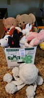 Full view of the box with a variety of vintage stuffed animals inside, including teddy bears and other animals.