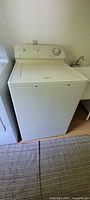 Front and side view of white top-loading Maytag washing machine