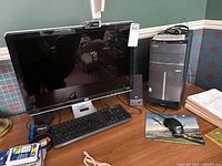 Full view of Acer desktop tower alongside HP w2207 monitor, keyboard, mouse, speakers, and webcam on a wooden desk.