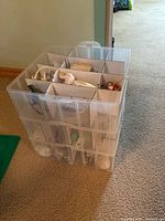 Clear plastic organizer box filled with Christmas ornaments separated by cardboard dividers