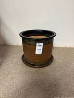Front view of ceramic planter showing textured diamond pattern, brown color with dark glazed rim, and matching saucer