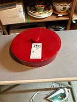 Top view of red covered baking dish with its lid and MaxSold tag visible.