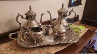 Full coffee and tea service set on decorative cloth, showing all pieces on the tray.