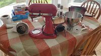 Red KitchenAid stand mixer and attachments on table