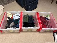 Three plastic bins filled with assorted gloves, mittens, caps, and winter hats.