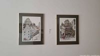 Two framed art prints by Mosher featuring Quebec City theme hanging on a wall.