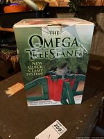 Box of the Omega Tree Stand showing branding and product image on the front.