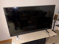 Front view of TV on stand with remote placed in front