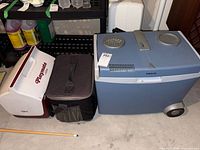 Three coolers displayed side by side: white and red Igloo hard-sided cooler, black soft cooler, and large blue Mobicool hard cooler on wheels.