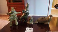 Front view of all four soapstone figurines: Inukshuk, dancing bear, seal and walrus on table