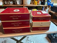 Three large red presentation boxes and three smaller beige boxes stacked on a table