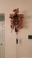 Front view of vintage wooden Black Forest style cuckoo clock mounted on wall