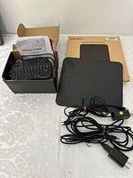 Android TV Box user manual and wireless mini keyboard in open box, Pendoo Digital HDTV Antenna and cables.