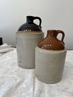 Photo showing both crocks together on a white tablecloth, highlighting size difference and overall appearance.