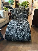 Front view of chaise lounger showing curved shape and floral upholstery pattern.