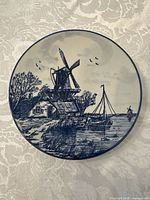 Front view of the plate showing detailed Delft Blue scene of windmill, boats, and landscape.