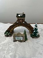 Front view of the Abington Bridge miniature and the separate Welcome sign with snow details and small trees around.