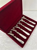 Set of six silver plated cheese/dip spreaders with detailed reindeer handles, displayed in red velvet lined box.
