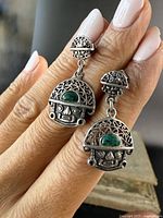 Front side close-up of the pair of sterling silver malachite drop earrings showing detailed filigree work and malachite stone in each earring.