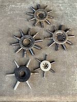 Five vintage metal watchmaker multi-tool keys of various sizes, arranged on fabric surface.