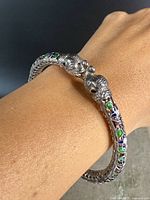 Bracelet worn on wrist showing double elephant heads and enamel decoration.