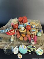 Overview of entire antique Asian jewelry collection spread on a surface showing bracelets, carved coral beads, cloisonné beads, and hand-painted pendants.
