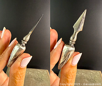 Two views of one sterling silver antique corn-cob holder showing the pointed prong and detailed corn texture on handle.