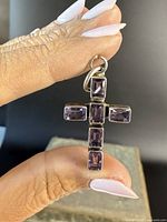 Front view of the sterling silver cross pendant showing five rectangular amethyst stones arranged vertically and horizontally forming the crucifix.