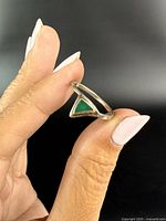 Side view of sterling silver ring showing green triangular stone.