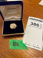 Ring in blue ‘Tradition’ box with handwritten green tape ‘10K’ and MaxSold lot card