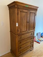 Full front view of wooden cabinet showing four drawers and two doors