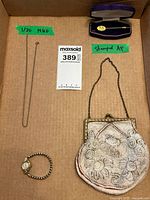 Jewellery lot items including watch, necklace, beaded purse, presented on cardboard with notes.