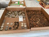 Two cardboard trays showing a spread of Canadian silver coins and a dense group of copper pennies