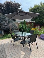 Assembled patio set on brick paver patio under umbrella