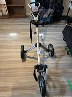 Overview of the 3-wheel golf push cart with its silver frame and black wheels, showing the structure and wheel configuration.