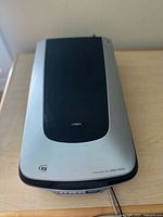 Top view of the Epson Perfection 4990 Photo scanner showing its silver and black casing with the Epson logo on the lid.