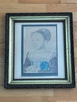 Framed portrait of Marguerite de Valois, showing entire artwork and frame facing forward on floor.