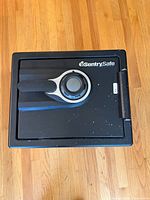 Top-front view of the black SentrySafe home safe with combination dial lock and handle