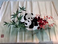 Embroidery artwork showing mother and baby panda with bamboo and red flowers on a light fabric background