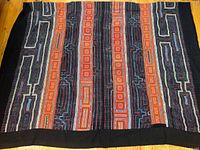Full view of the vintage Hmong textile throw showing overall pattern and color scheme with framed edges.