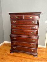 Front view of vintage Sumter Cabinet Company wooden dresser with brass handles on multiple drawers