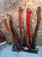 Group of six mattocks/pickaxes leaning against wall