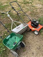 Husqvarna lawnmower, Highland seeder, Scotts spreader grouped outdoors