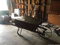 Side view of wooden wheelbarrow showing metal spoke wheel and handles
